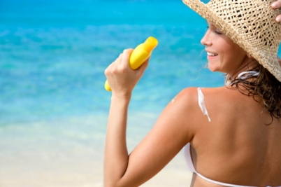 woman with suntan lotion on tropical beach